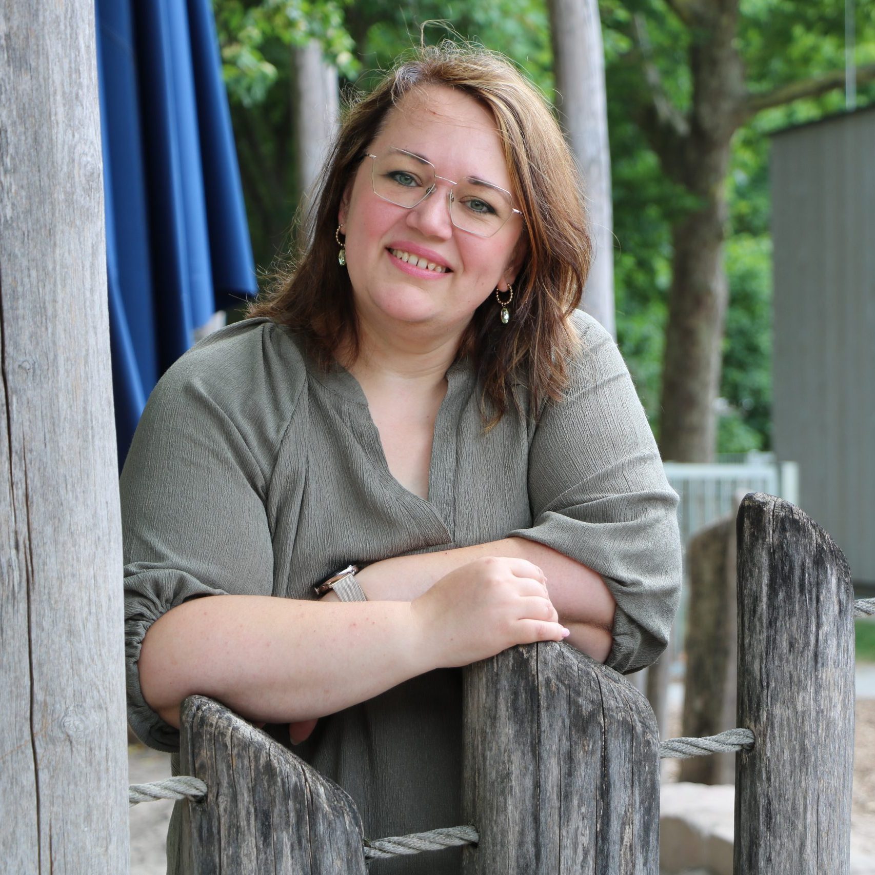 Frau auf Kinderspielplatz, lächelnd.